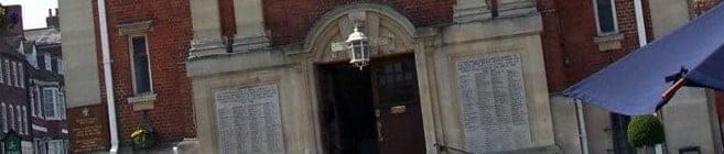 Rote Backsteinkirche mit Eingangstür und Namensschildern