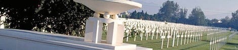 Friedhof mit weißen Kreuzen und einem Denkmalgebäude