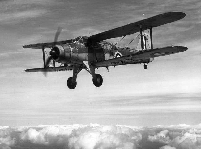 Historisch Brits tweedekker vliegtuig vliegt boven wolken